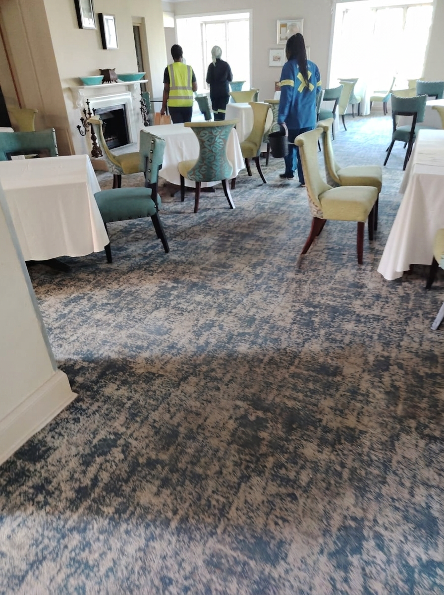 Cleaning professionals in a carpeted dining room